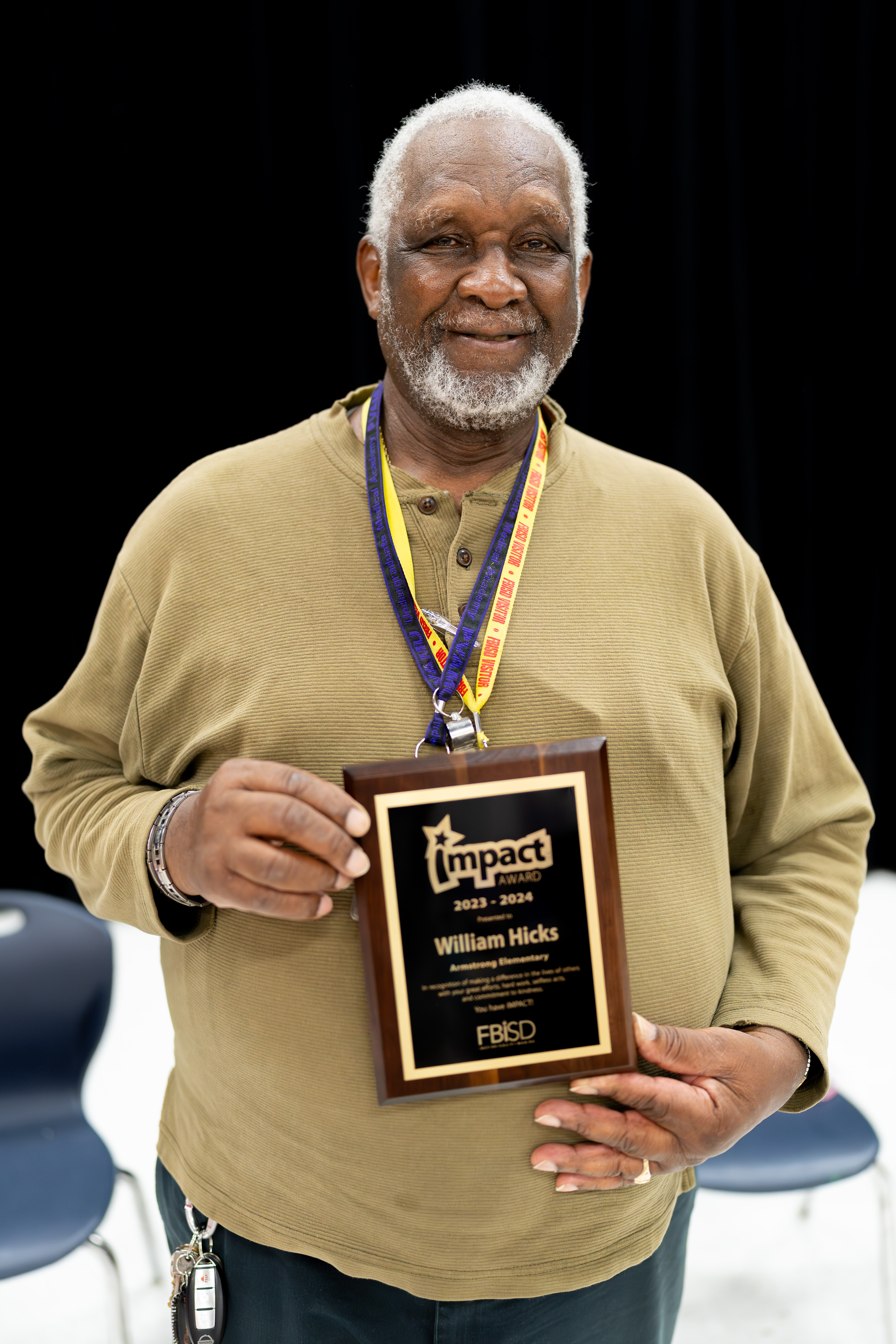 William Hicks holding the Impact Award plaque